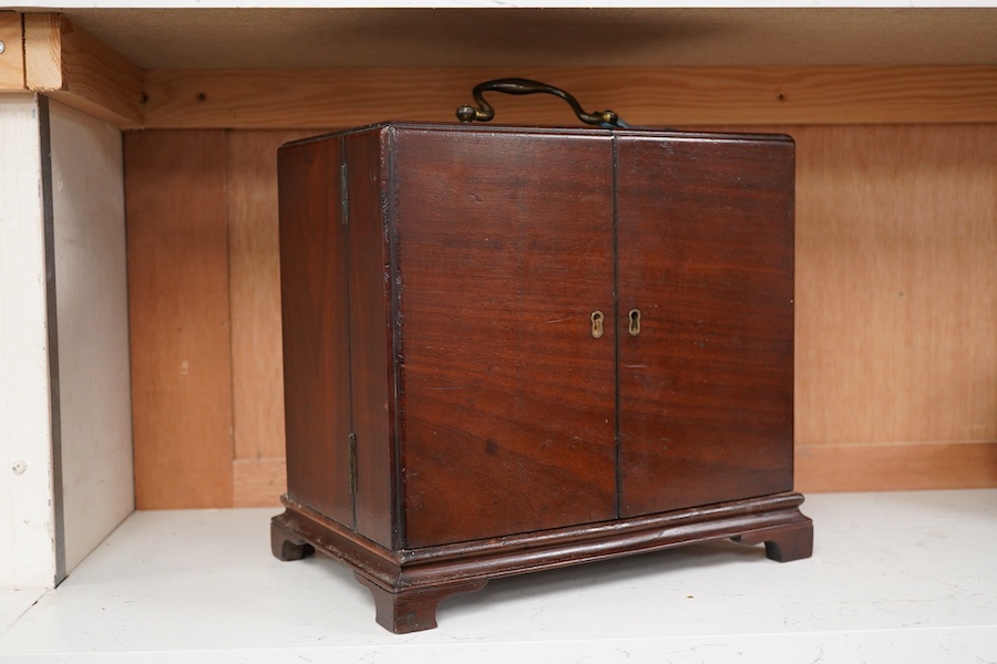 A 19th century mahogany apothecary cabinet, interior with fitting compartments containing twenty-one glass bottles, most with stoppers, five drawers with ivory knobs containing a miniature pestle and water, mixing glasse